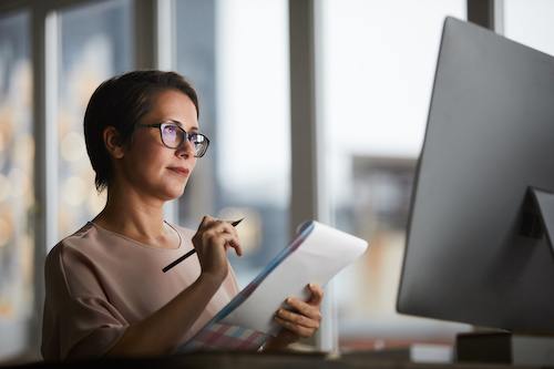 A businesswoman reviewing the differences between Oracle NetSuite and Quickbooks