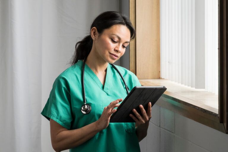 A healthcare professional using NetSuite solutions to review their financial performance on her tablet.